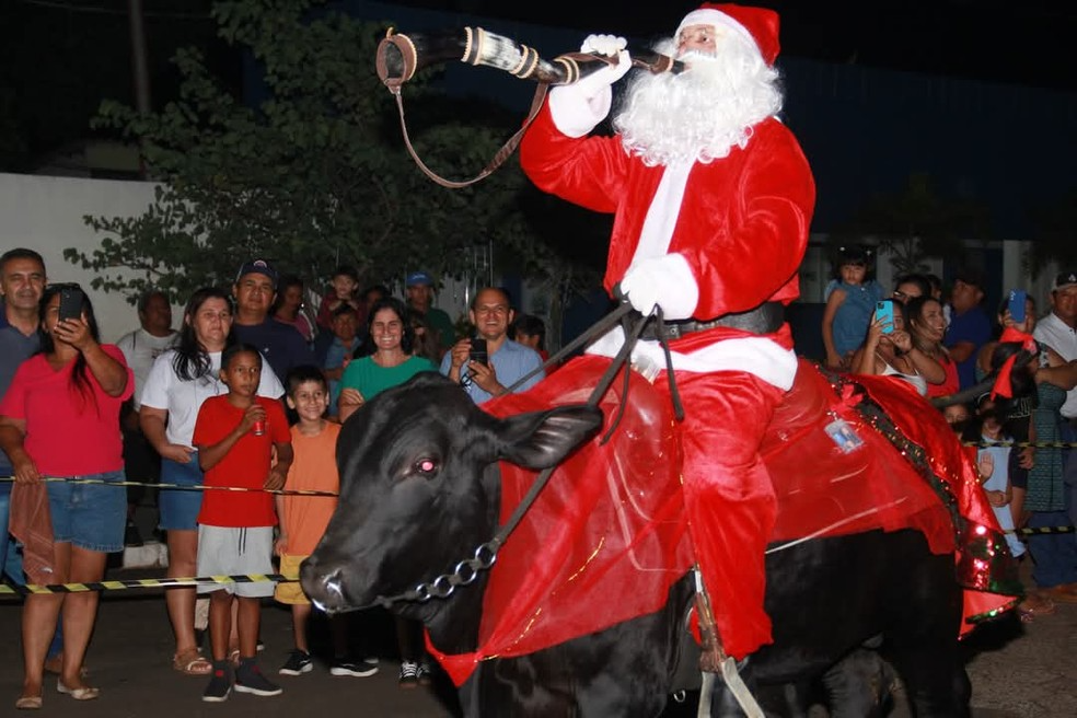 Em MS, Papai Noel chega montado em boi e toca berrante